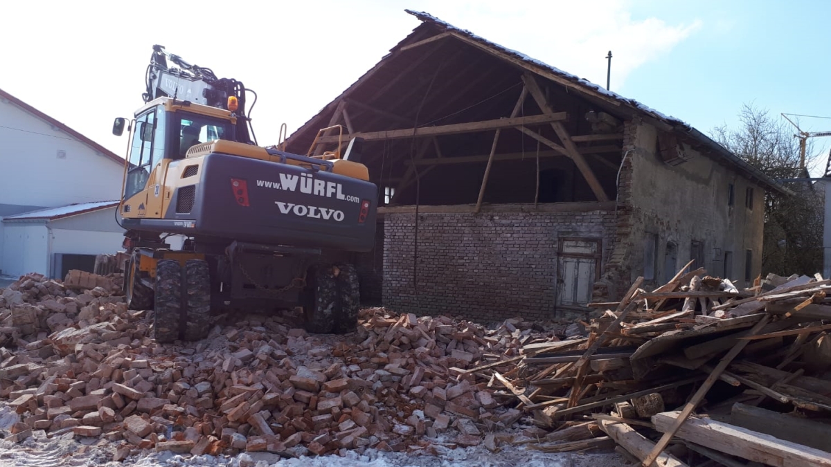 Beispielbild für Abbruch: Ein Bagger beim Abbruch eines älteren Hauses.
