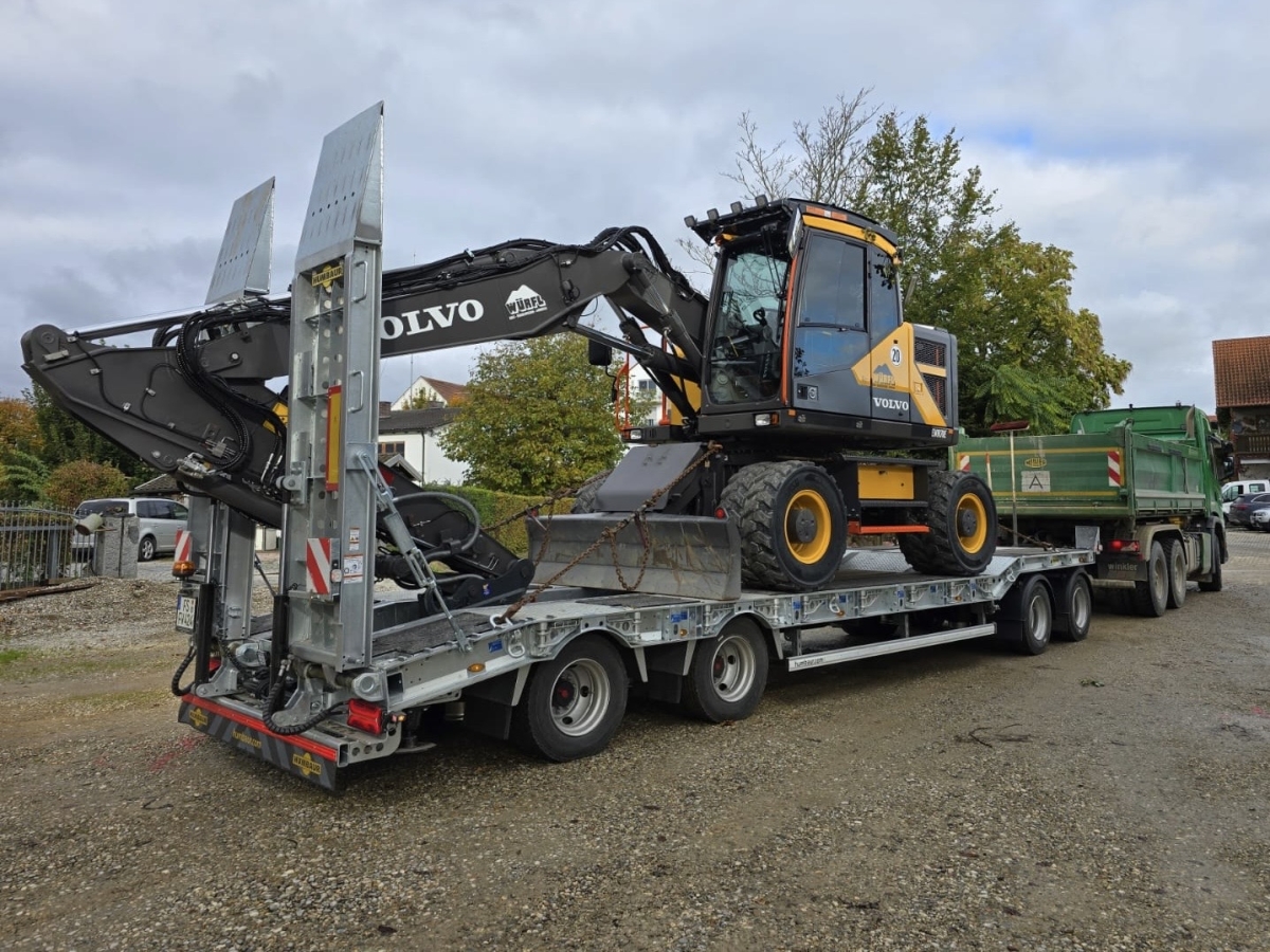Beispielbild für unseren Fuhrpark: Bagger auf Anhänger eines LKWs